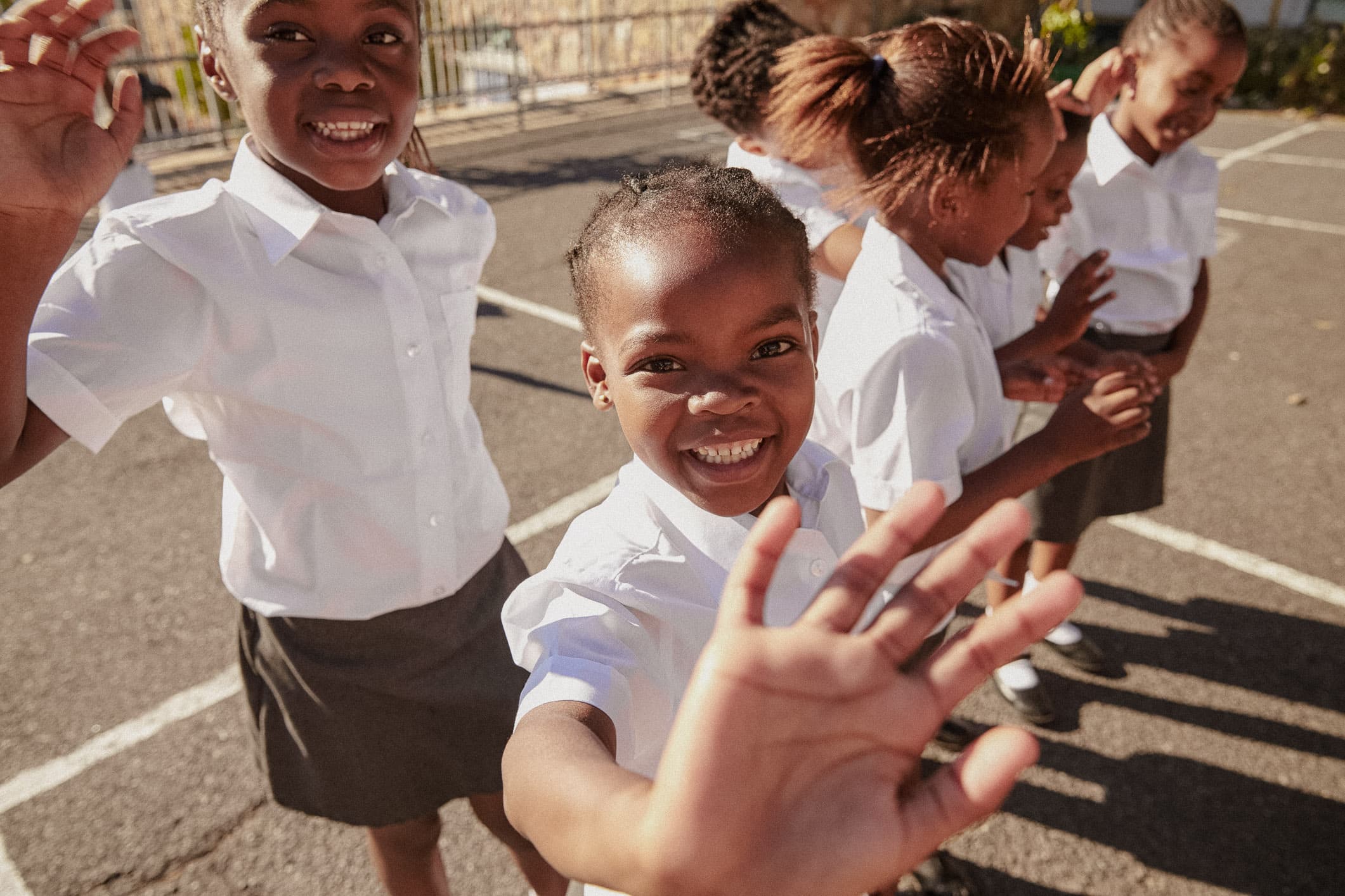 School children waving to camera